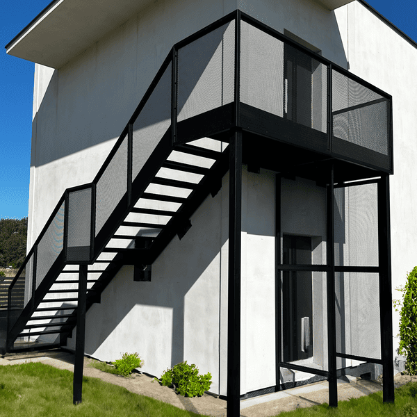 Zewnętrzne schody stalowe ażurowe – ryflowane stopnie i balustrada z siatki