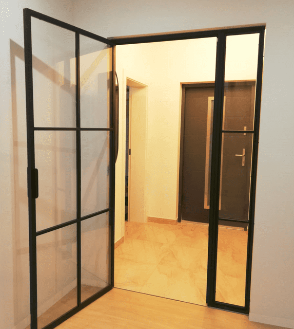 Loftvägg med transparent glas och inåtgående dörrar