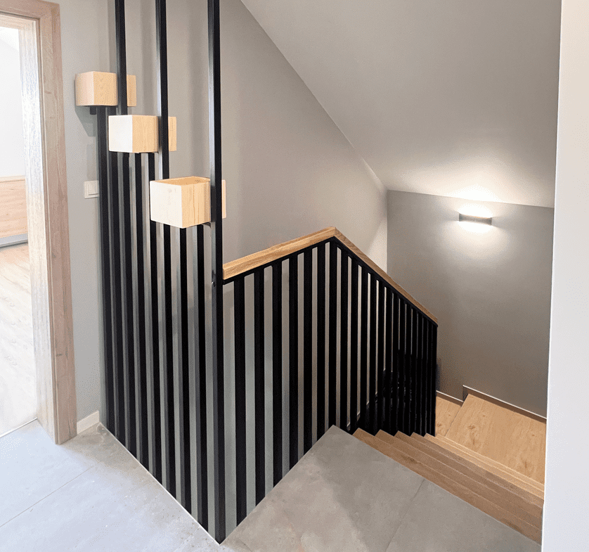 Svart metallräcke med träledstång